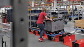 Kezelő rakodik meg egy feles méretű kocsival szerelt vontató-utánfutót