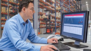 Fleet management with connect: Fleet management software Fleet manager sitting in front of a desktop with Linde connect, the fleet management system from Linde Material Handling Fleet management software