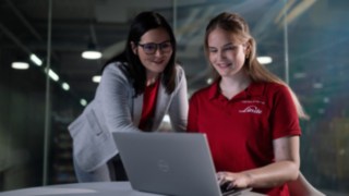 Két ember ül egy laptop előtt.