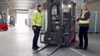 A Linde Safety Scan jelentősen támogatja a CTL-nél a munkabiztonságot. Két CTL-munkatárs áll a Linde Anyagmozgatás E30 típusú elektromos targoncája mellett.