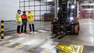 Konzultáció több személy között egy üzemcsarnokban. Konzultáció több személy között egy üzemcsarnokban.