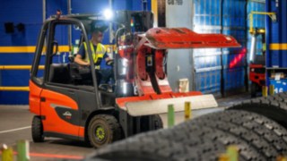 A Michelin Tyre PLC munkatársa egy Linde E20-as targonca abroncsfogójával nyúl egy gumiabroncsrakat után.