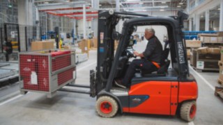 Egy Linde elektromos targonca rácsos ládát szállít