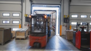 Egy Linde elektromos targonca a rakodórámpán keresztül rakományt rakodik teherautóra