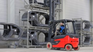 A Linde Anyagmozgatás megoldásokat kínál az autóipar kulcsfontosságú intralogisztikai kihívásaira. A Linde egy targoncája karosszériaelemekkel megrakott polchoz hajt