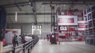 Luis és Kimsy felfedezi a Linde raktári megoldásait a WoMH 2022 kiállításon, többek között a K-berendezést és az R20 tolóoszlopos targoncát.