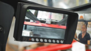 A Linde tolóoszlopos targoncáiba épített kamerarendszer kijelzője a rakomány alsó részét és a polcrendszeren belüli munkaterületet mutatja. A Linde tolóoszlopos targoncáinak oszlopára szerelt kamerarendszer segítségével a vezető biztonságosan tudja pozicionálni a rakományt a polcrendszerben.